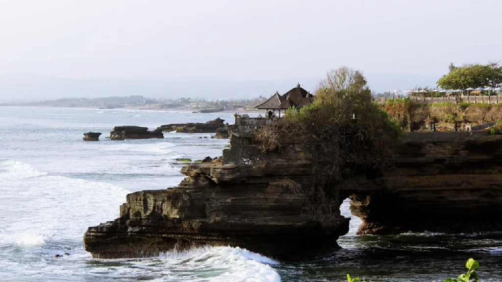 Batu Bolong Temple cliffside view included in Bedugul Tanah Lot Tour itinerary